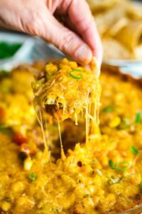 This Hot 7 Layer Dip is the ultimate game day or party recipe! It's super quick and easy to make and that melty cheese will keep everyone coming back for more!