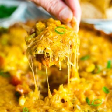 This Hot 7 Layer Dip is the ultimate game day or party recipe! It's super quick and easy to make and that melty cheese will keep everyone coming back for more!