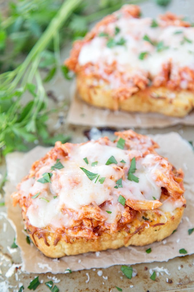 Shredded chicken in tomato and topped with cheese on a slice of texas toast.