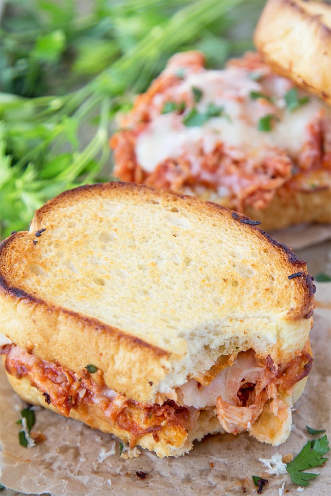 A Shredded Chicken Parmesan sandwich with a bite taken out of it.