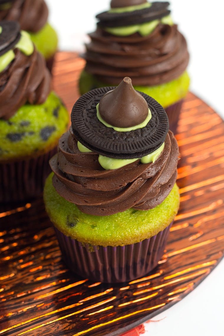 Witch Hat Cupcakes - These cupcakes are a green and black colored yellow cake mix, topped with a homemade chocolate frosting, a drizzle of green candy melt and finished with a cute little witch hat. These are the perfect halloween treat for kids!
