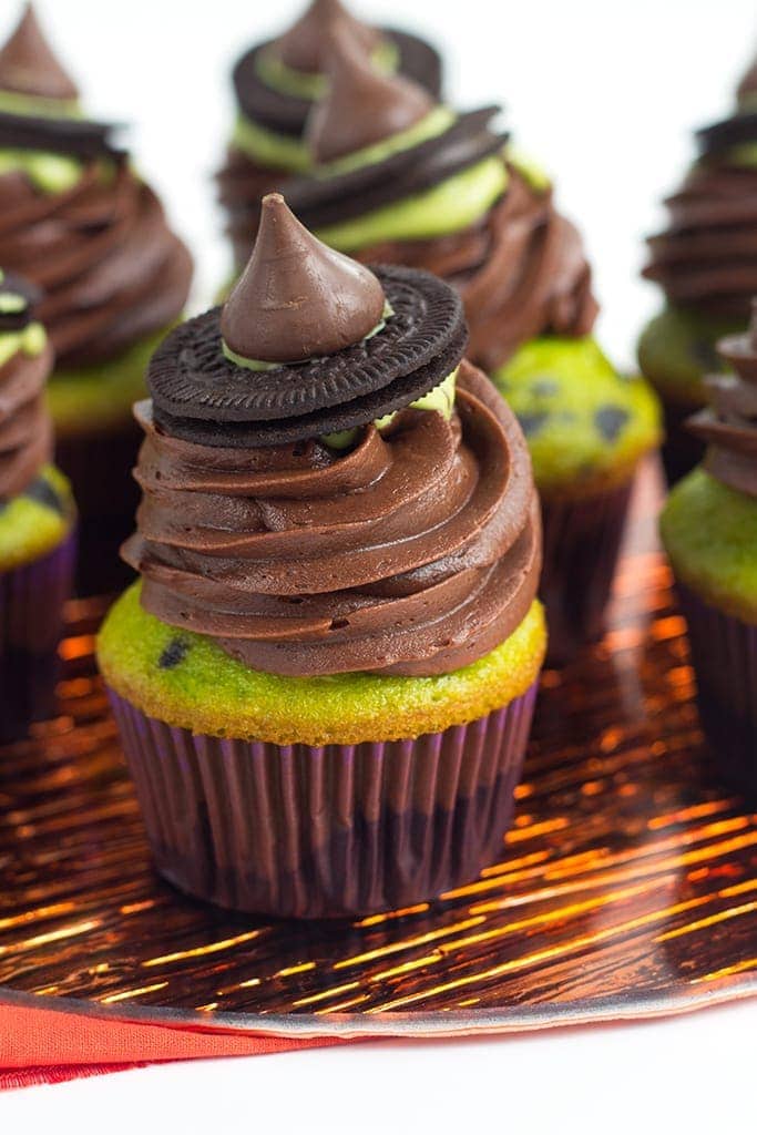 Witch Hat Cupcakes - These cupcakes are a green and black colored yellow cake mix, topped with a homemade chocolate frosting, a drizzle of green candy melt and finished with a cute little witch hat. These are the perfect halloween treat for kids!