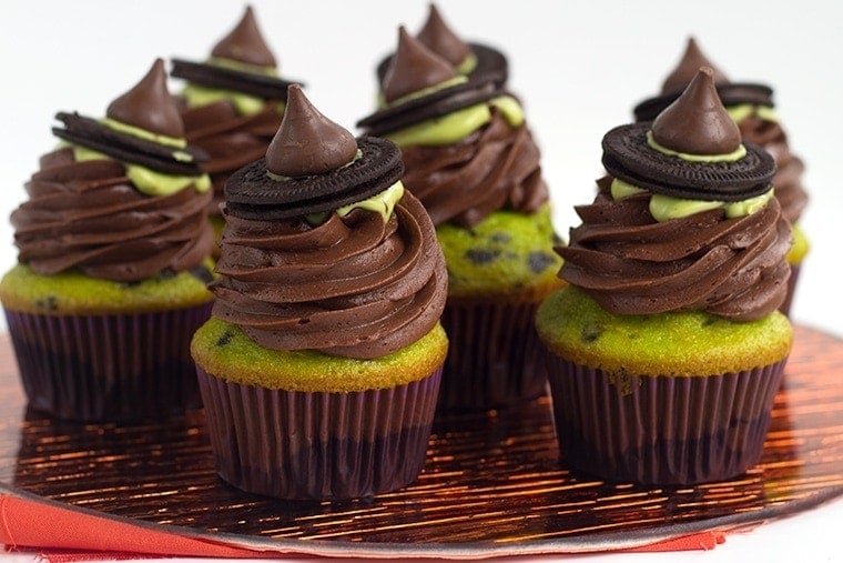 Witch Hat Cupcakes - These cupcakes are a green and black colored yellow cake mix, topped with a homemade chocolate frosting, a drizzle of green candy melt and finished with a cute little witch hat. These are the perfect halloween treat for kids!