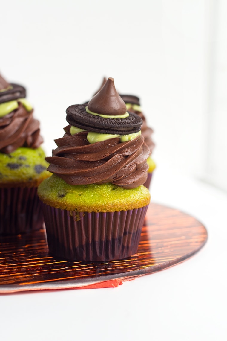 Witch Hat Cupcakes - These cupcakes are a green and black colored yellow cake mix, topped with a homemade chocolate frosting, a drizzle of green candy melt and finished with a cute little witch hat. These are the perfect halloween treat for kids!