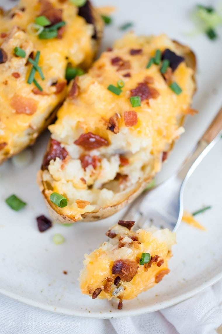 These Twice Baked Potatoes are stuffed to the brim with tender potato, cheddar and Parmesan cheeses and loads of bacon. A great side dish for any holiday!