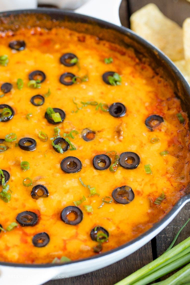 Cheesy Ground Beef Enchilada Dip in a Cast Iron Skillet topped with sliced olives and green onions