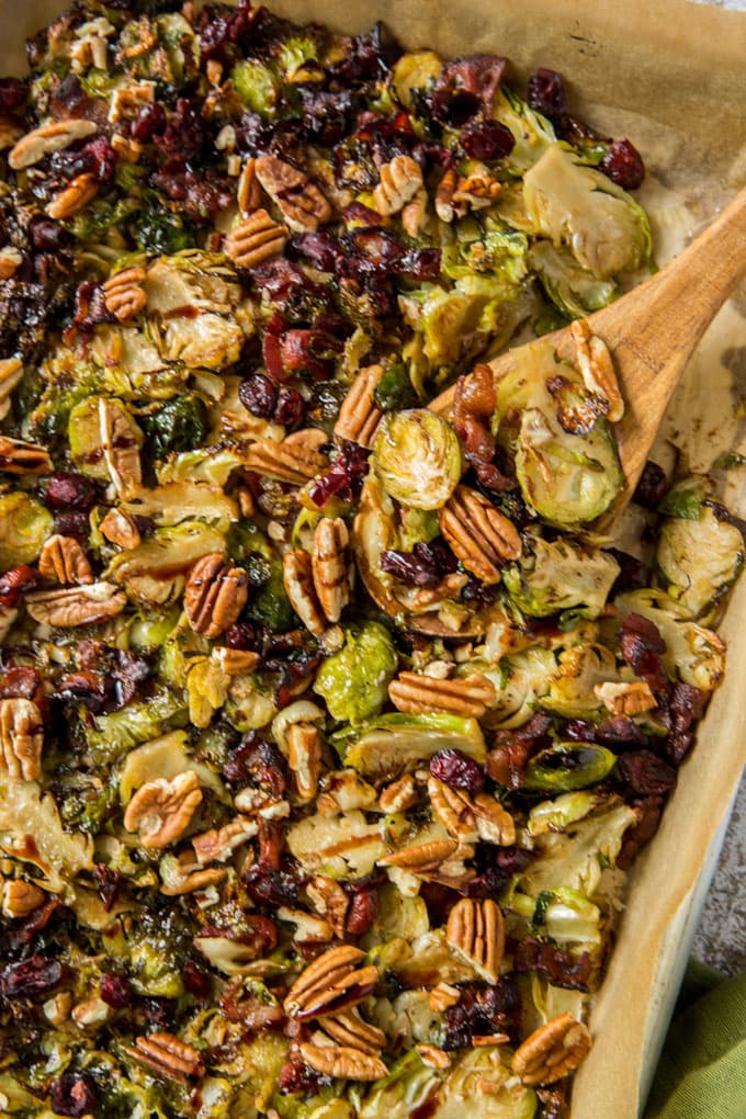 A pan of roasted brussels sprouts with cranberries, pecans and bacon