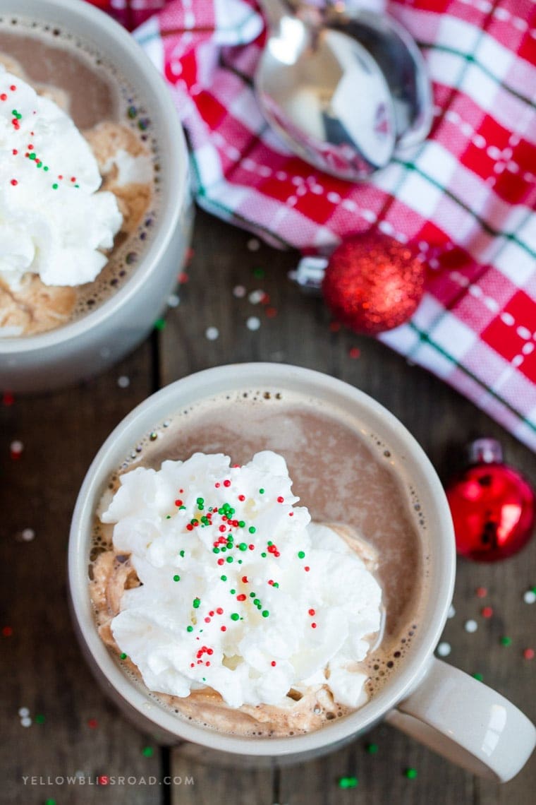 Gray mugs with chocolate drinks and whipped cream.
