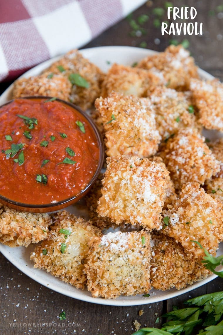 Fried ravioli on a plate with marinara and a title text.