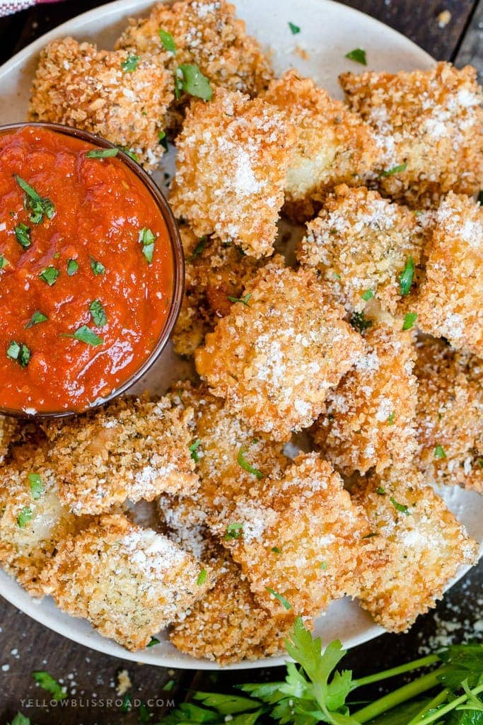 An overhead shot of a plate of fried ravioli with marinara.