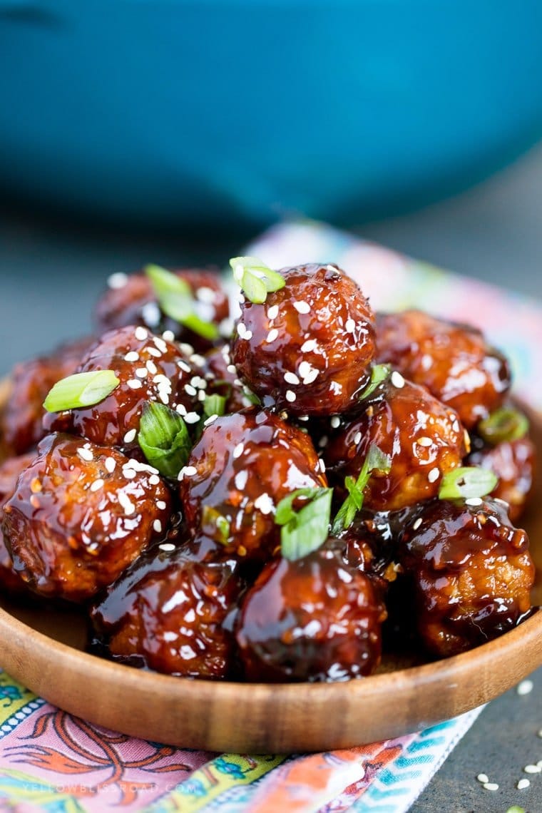 A plate of meatballs with sesame seeds and green onions