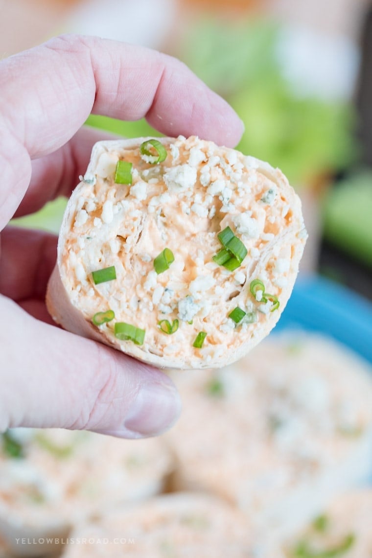 A hand holding a Buffalo Chicken Pinwheel