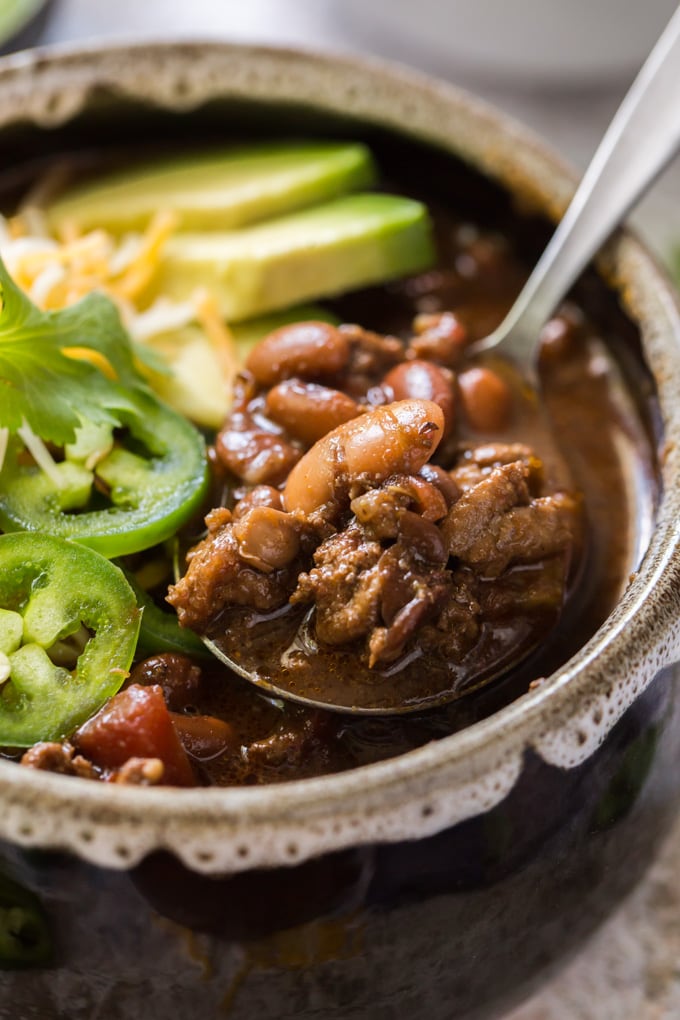 ground turkey and beans on a spoon in a bowl of chili