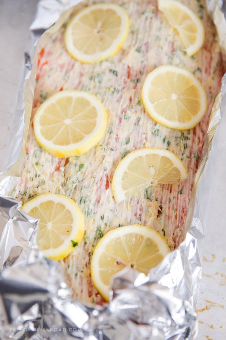 Piece of salmon covered with garlic butter and lemons