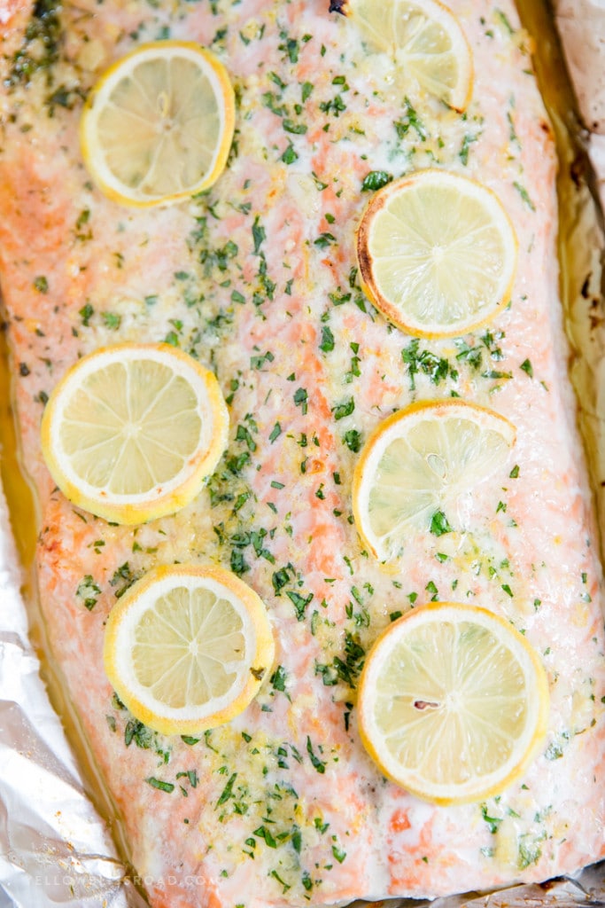 Piece of baked salmon covered with garlic butter and lemons