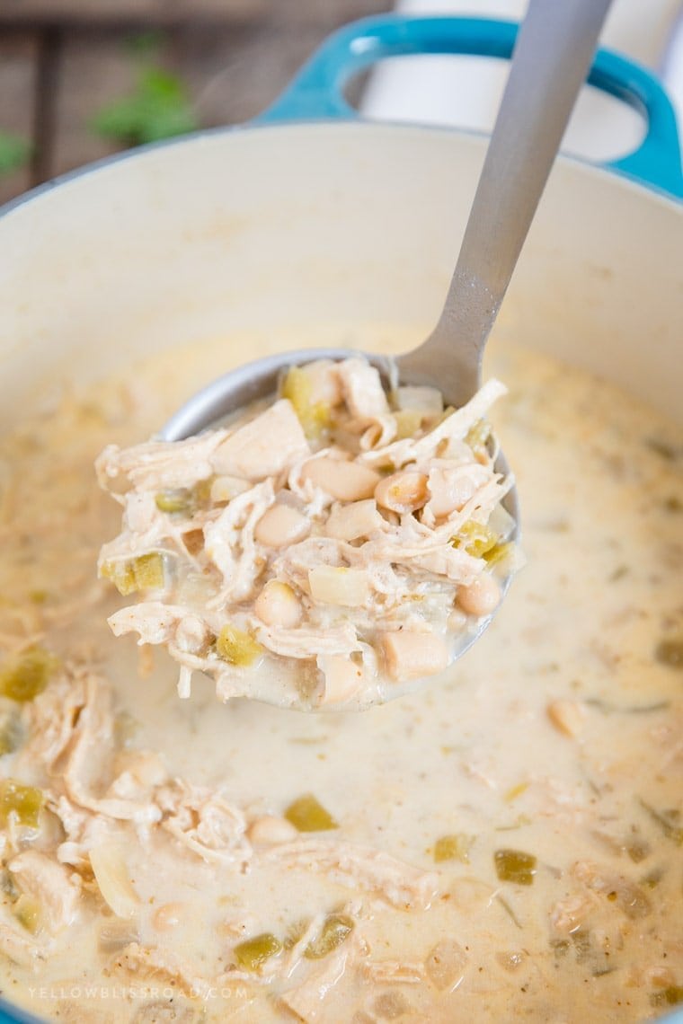 A ladle of White Chicken Chili in a soup pot