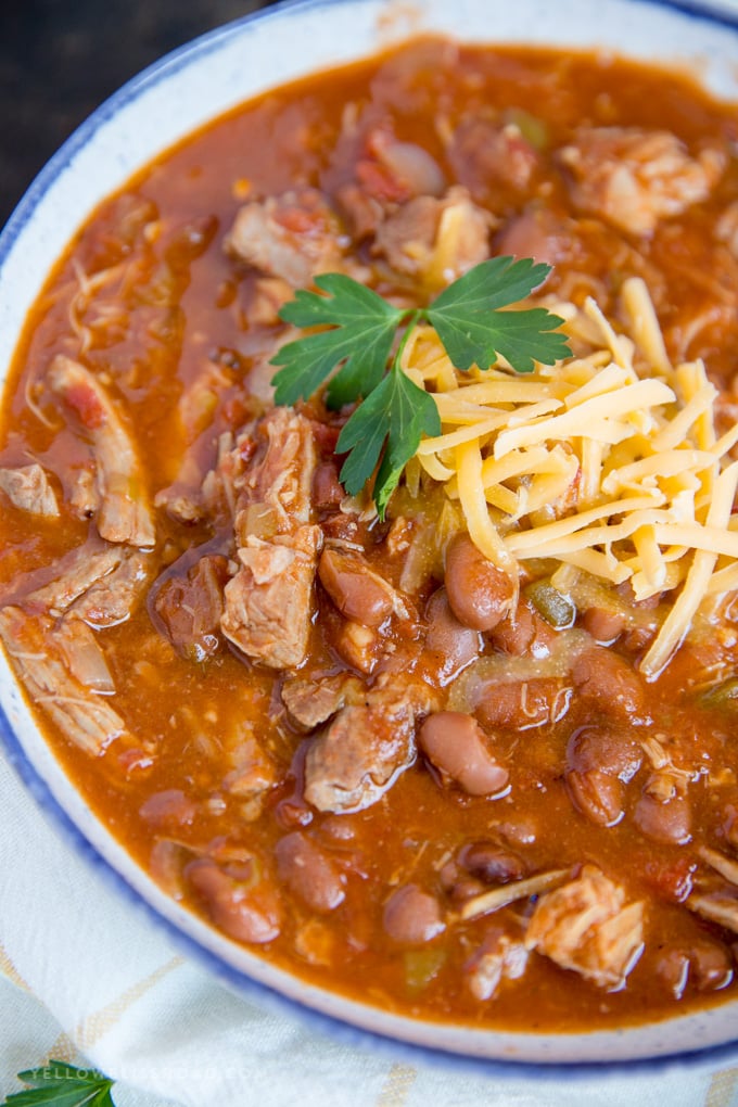 Slow Cooker Pulled Pork Chili with cheese and parsley garnish