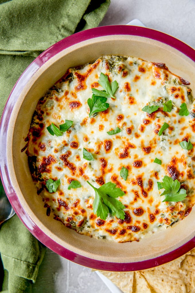 An overhead shot of baked spinach artichoke dip with browned mozzarella cheese.