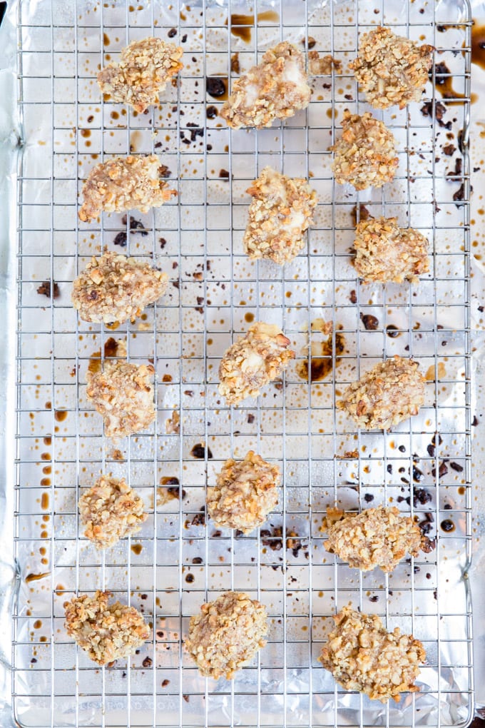 Walnut Crusted Baked Chicken Nuggets: tender, juicy chicken coated in crunchy walnuts and seasonings. Easy appetizer or dinner. #ad #californiawalnuts Walnut Crusted Baked Chicken Nuggets spread out on a baking rack over a baking sheet