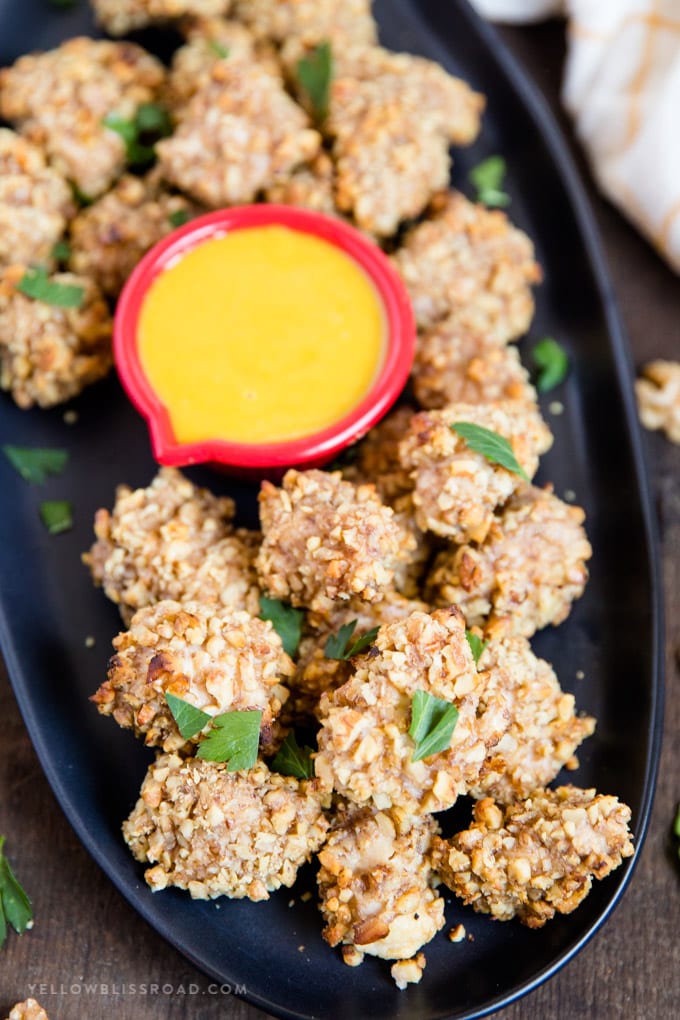 Walnut Crusted Baked Chicken Nuggets: tender, juicy chicken coated in crunchy walnuts and seasonings. Easy appetizer or dinner. #ad #californiawalnuts Walnut Crusted Baked Chicken Nuggets with honey mustard sauce