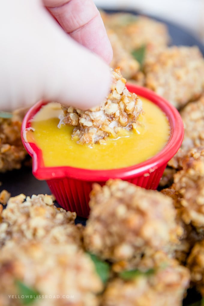 Walnut Crusted Baked Chicken Nugget being dipped into honey mustard sauce
