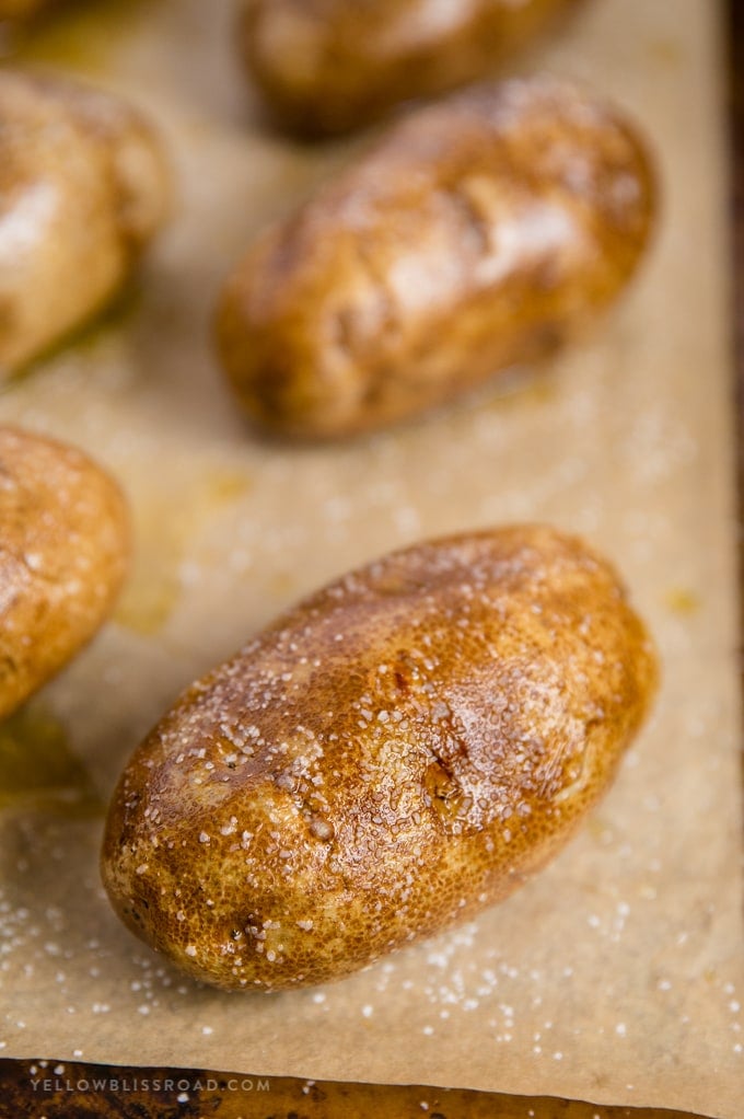 Baked potatoes are a super delicious and filling side dish for any meal. Learn how to bake potatoes in the oven with this easy recipe! Baked potatoes rubbed with oil and salt.