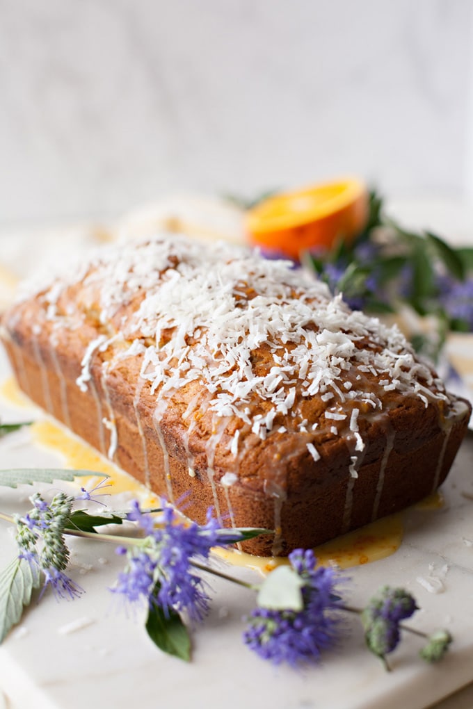 Coconut Banana Bread with Orange Glaze and shredded coconut on top. Perfect for Easter or Mother's Day!