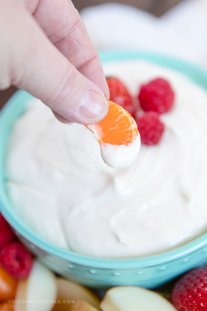 Orange slice dipped in Easy, 3 Ingredient Cream Cheese Fruit Dip 