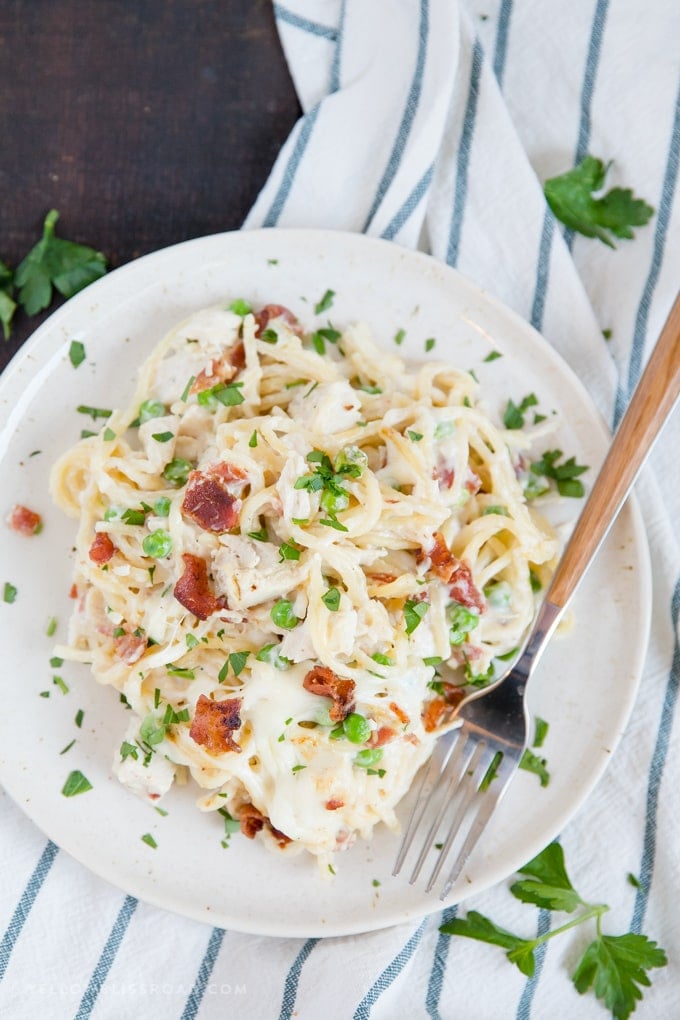 Creamy, Cheesy Chicken Spaghetti, with bacon, chicken, spaghetti and peas in a made from scratch sauce. Pure comfort food and perfect for a hearty weeknight meal. A plate of creamy chicken spaghetti with bacon, peas and a made from scratch cream soup sauce.