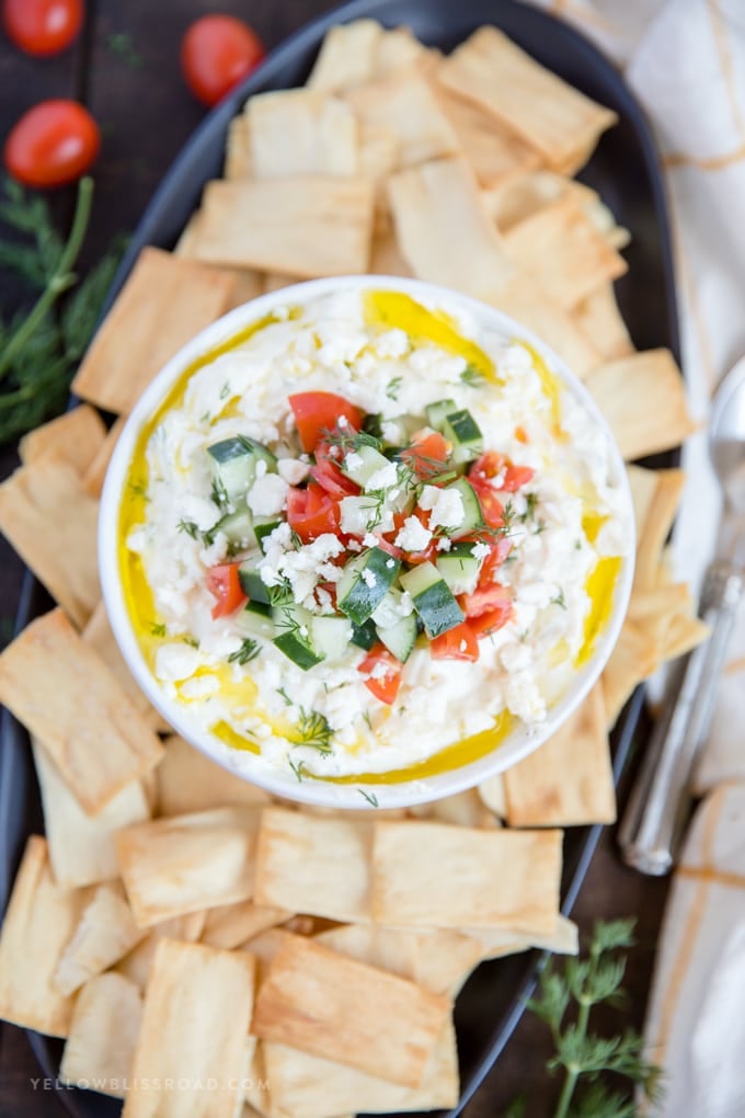 Greek feta cheese dip surrounded by pita chips and drizzled with olive oil
