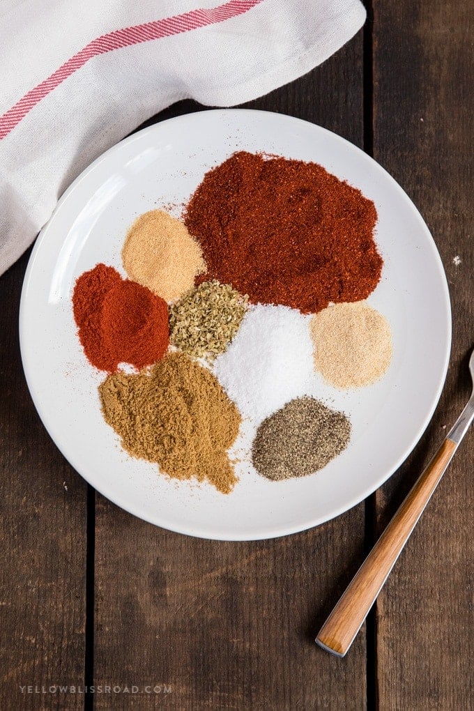 This homemade taco seasoning mix is super simple and easy. Whip up a batch and store it in your pantry for quick access when cooking tacos, burritos, nachos and more! Homemade taco seasoning divided into separate ingredients on a plate