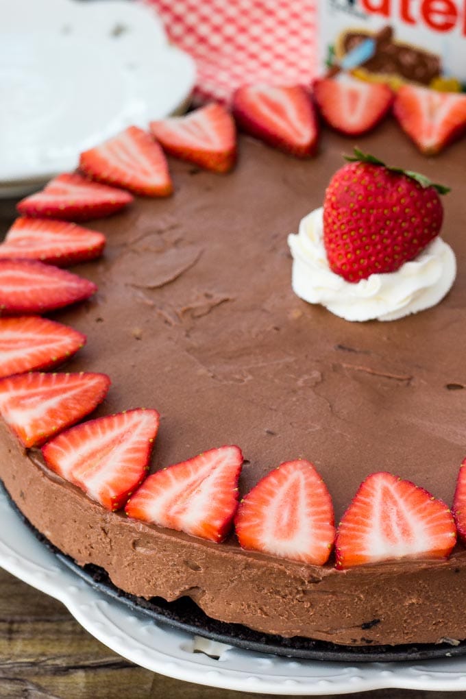 Nutella cheesecake topped with strawberries and whipped cream. 