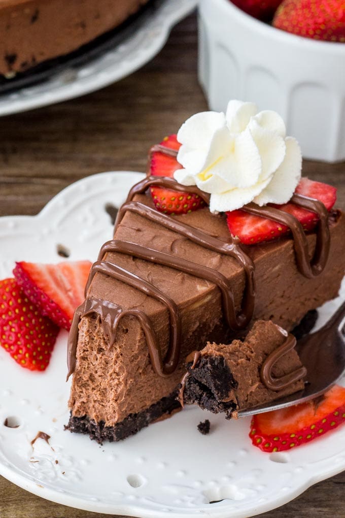 No Bake Nutella Cheesecake is smooth, creamy and filled with Nutella. It's a decadent cheesecake recipe thanks to the chocolate cookie crust and rich Nutella flavor and it's so easy to make! A slice of no bake Nutella cheesecake drizzled with more Nutella