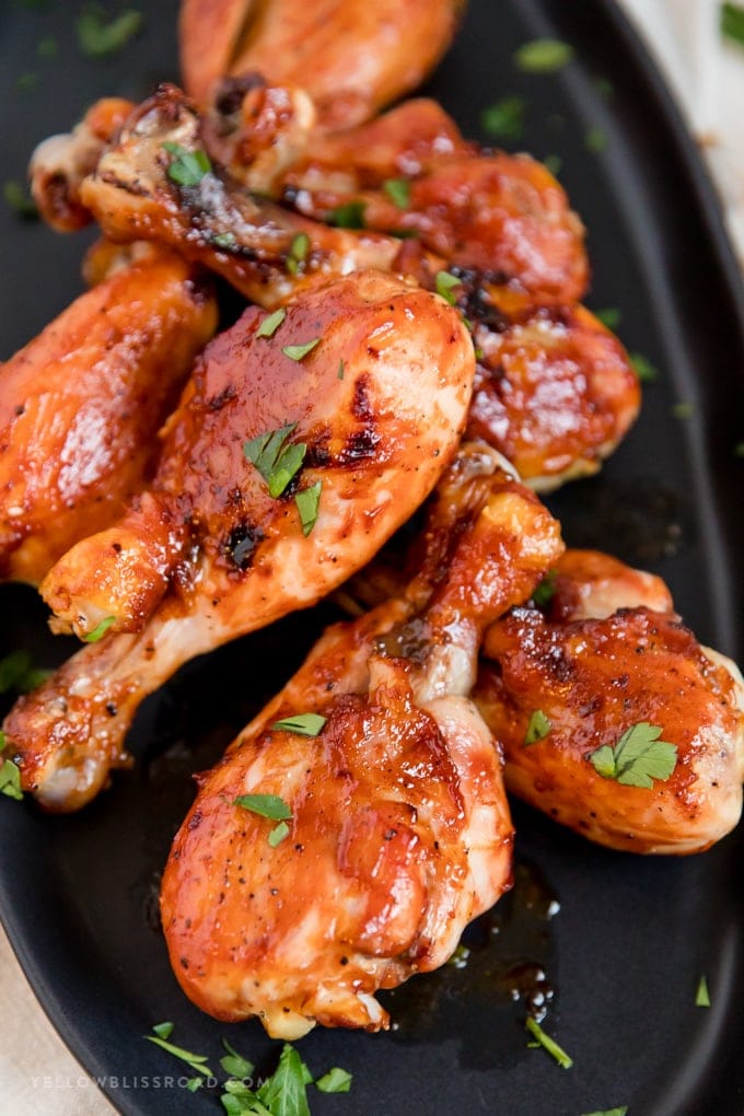Barbecue Baked Chicken Drumsticks arranged on a plate with parsley garnish.