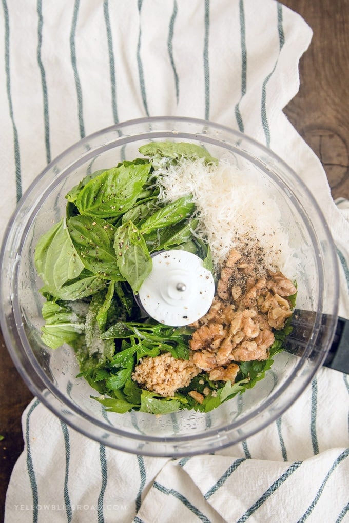 Basil, parsley, garlic, parmesan cheese and walnuts in a food processor to make Walnut Basil Pesto recipe 