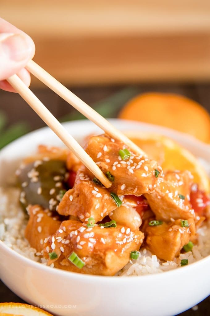 Crockpot Orange Chicken with chopsticks and on a bed or rice