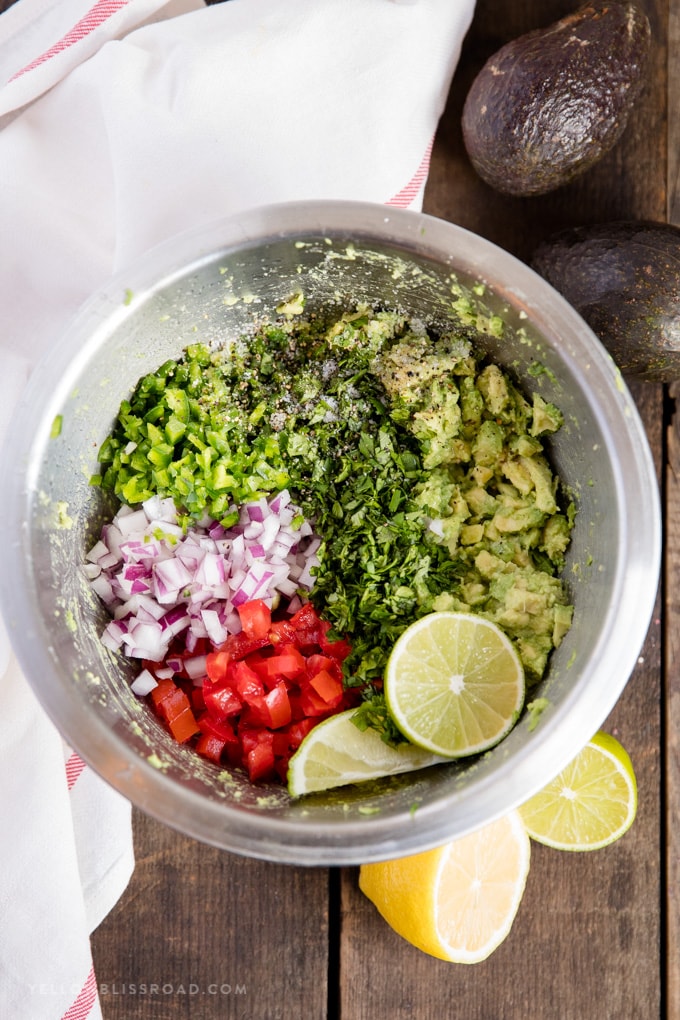 a bowl filled with ingredients to make the best guacamole