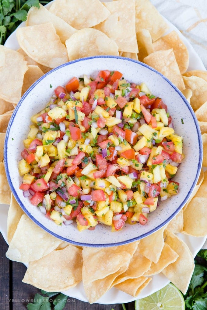 fresh pineapple salsa in a bowl with lots of tortilla chips