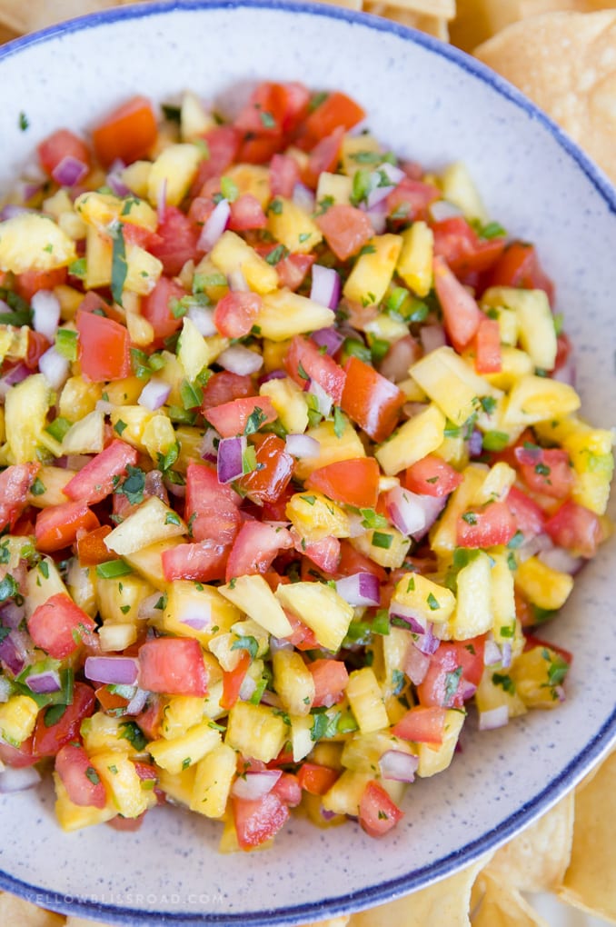 My fresh and easy Pineapple Salsa is sweet and spicy and so full of flavor that is delicious with chips or as a topping on chicken, tacos and more! #chipsanddip #pineapple #salsa fresh pineapple salsa in a bowl with chips