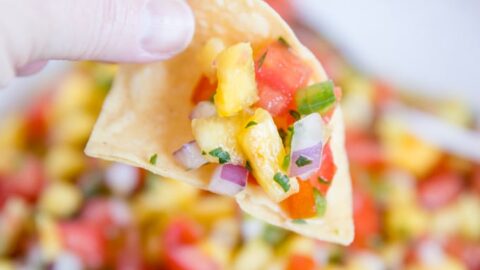 Chip dipping into bowl of Fresh Pineapple Salsa