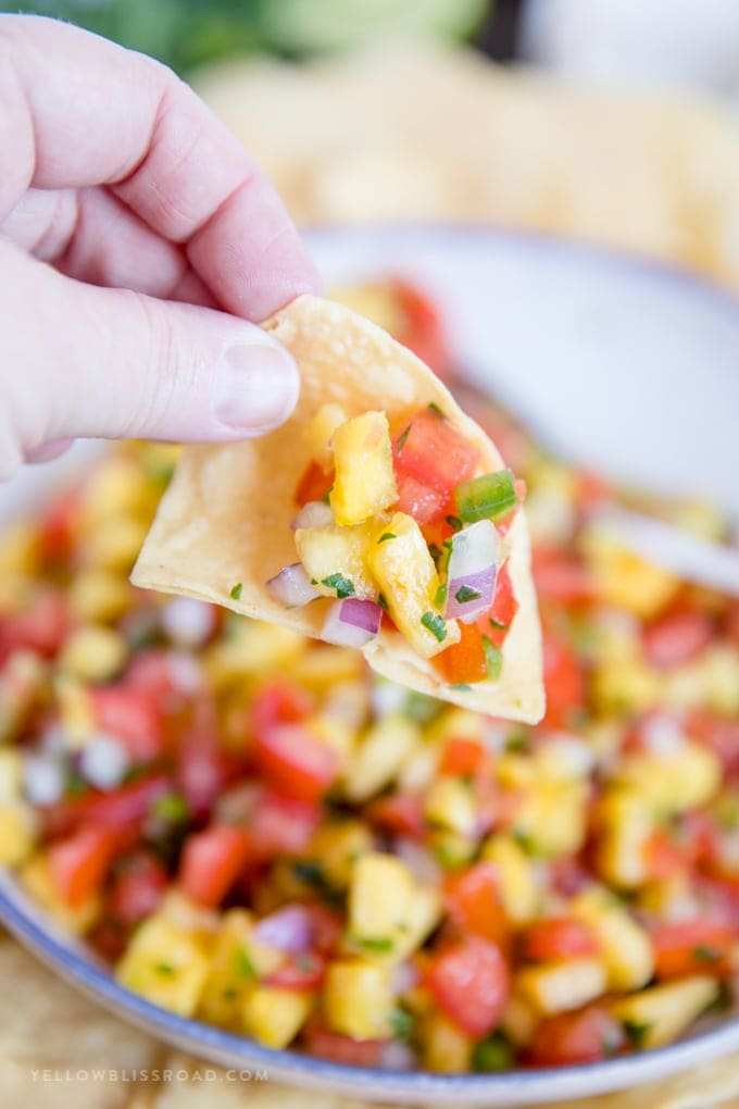 Chip dipping into bowl of Fresh Pineapple Salsa