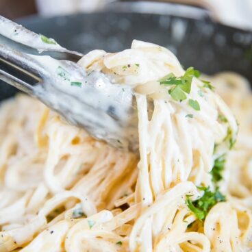 A close up of noodles with alfredo sauce