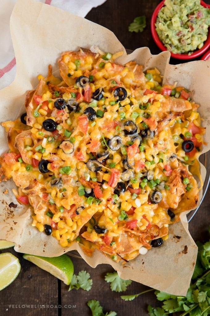 Chicken Nachos are easy, cheesy, and loaded with layers of chicken, veggies and cheese. This easy nachos recipe is perfect for one or a crowd.