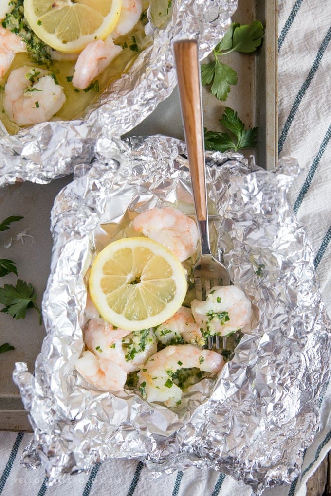 Shrimp Foil Packets with lemon herb butter spread open with a fork