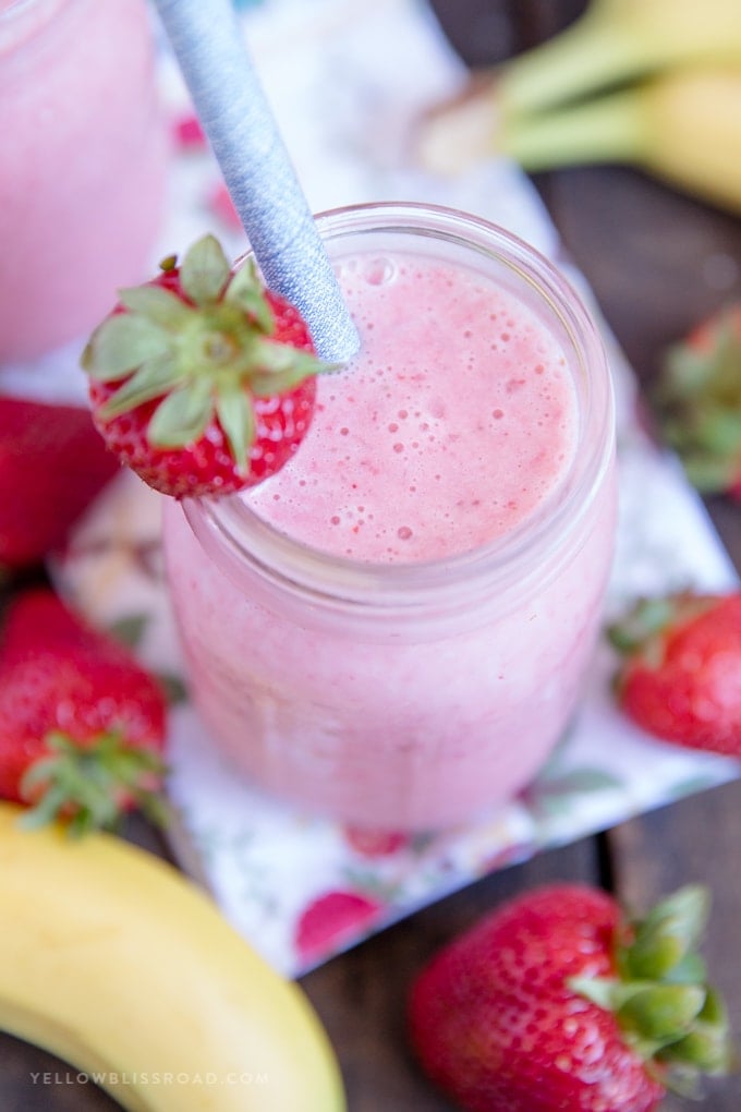 Learn how to make a Strawberry Banana Smoothie with this easy recipe! Just four ingredients for a creamy, healthy, delicious smoothie that everyone will love. Overhead photo of a strawberry banana smoothie in a mason jar
