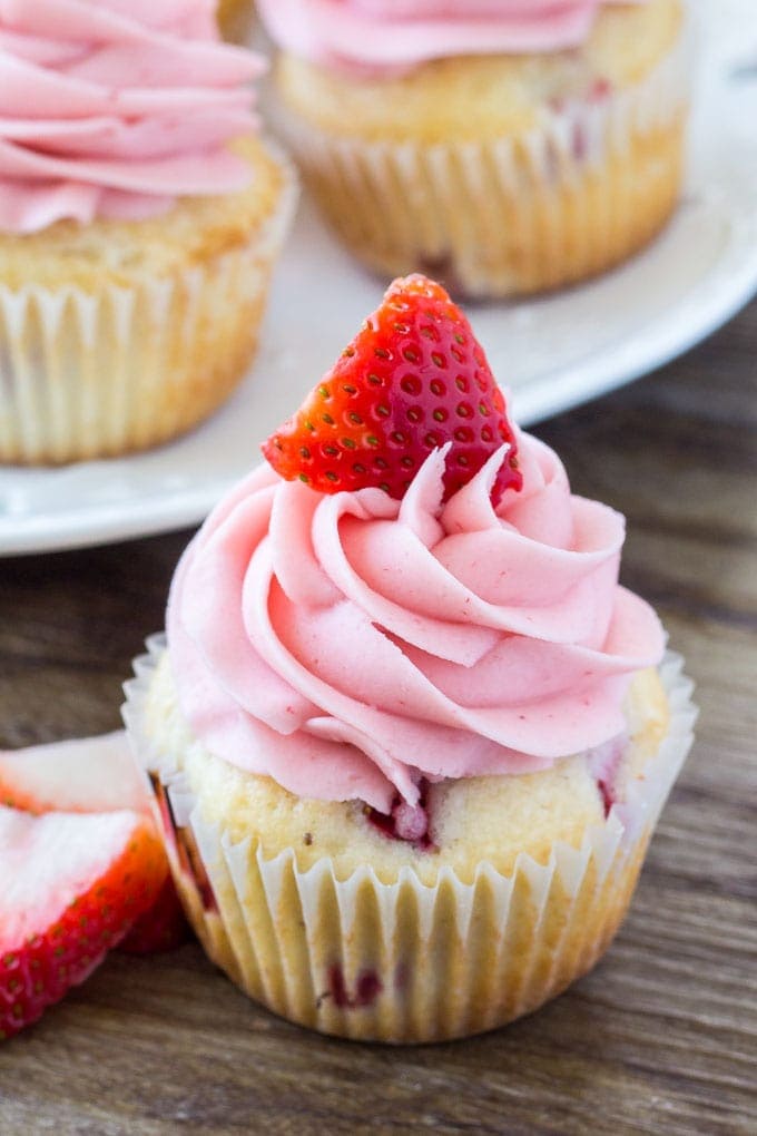 Strawberry cupcakes - moist vanilla cupcakes filled with strawberries and topped with strawberry frosting. 