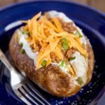 A blue plate with a taco stuffed potato