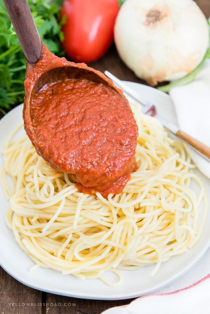 Easy Homemade Spaghetti Sauce - Simple to make and so much better than jarred. Make a double or triple batch to freeze for later so you're always ready for spaghetti night! Easy Homemade Spaghetti Sauce spooned out onto a pile of spaghetti