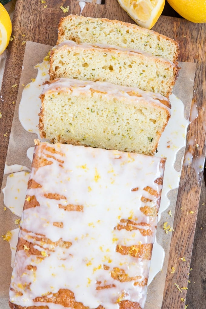 a loaf of lemon zucchini bread with three slices cut