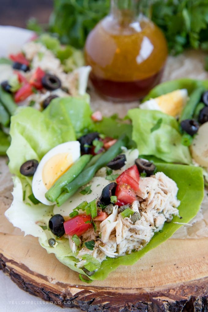 Nicoise Salad Lettuce Wraps on a wood slice